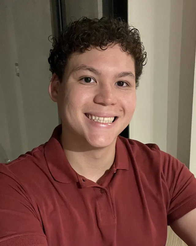 Gabriel Lacerda sorrindo, de camisa polo vinho